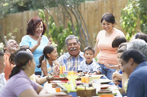 A multi-generational family gathered together for a meal, laughing and enjoying each other's company