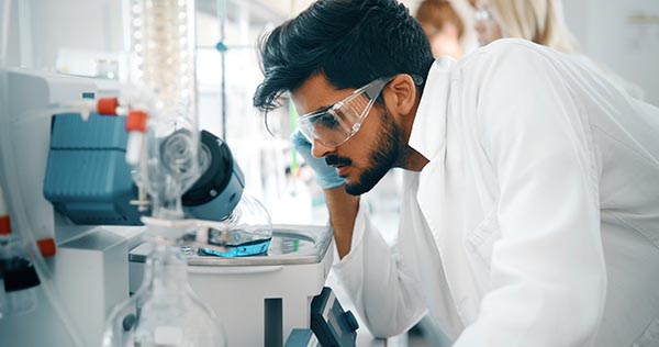 Researcher in a laboratory, analyzing an experiment and making observations about the chemical reaction taking place