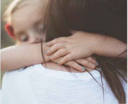 Child being held by a caregiver