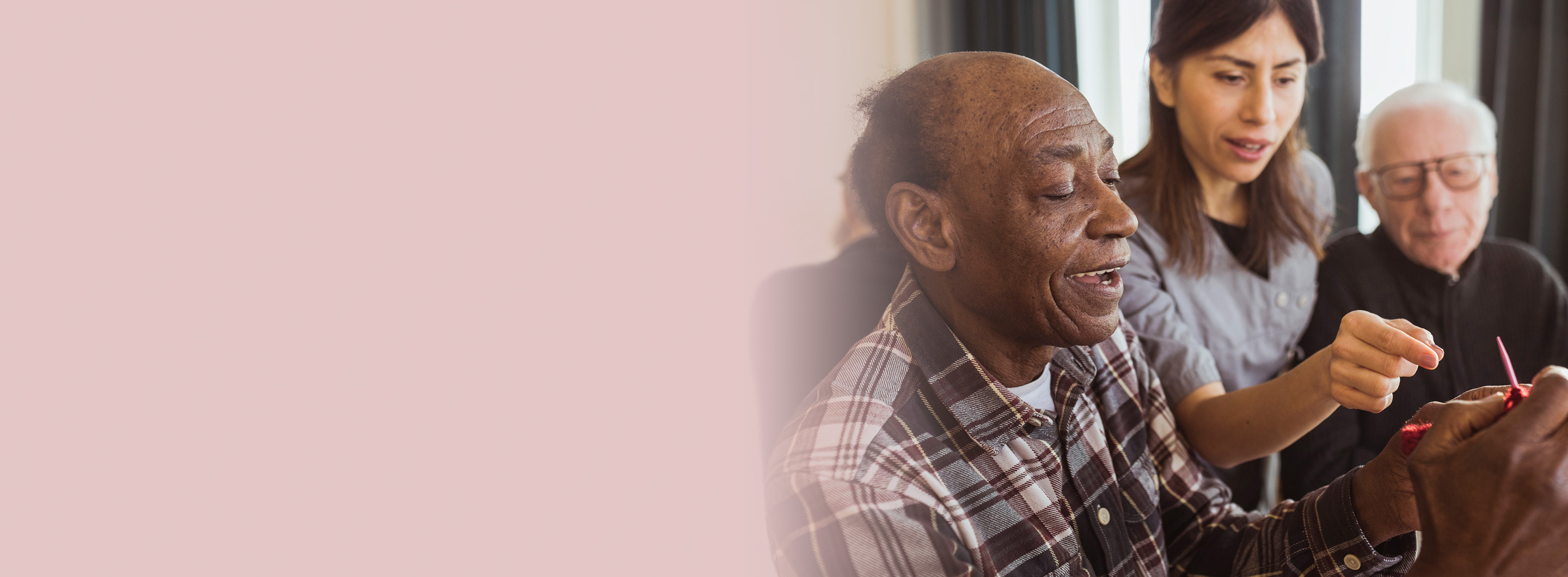 Caregiver helping an older man with a task, promoting independence and dignity